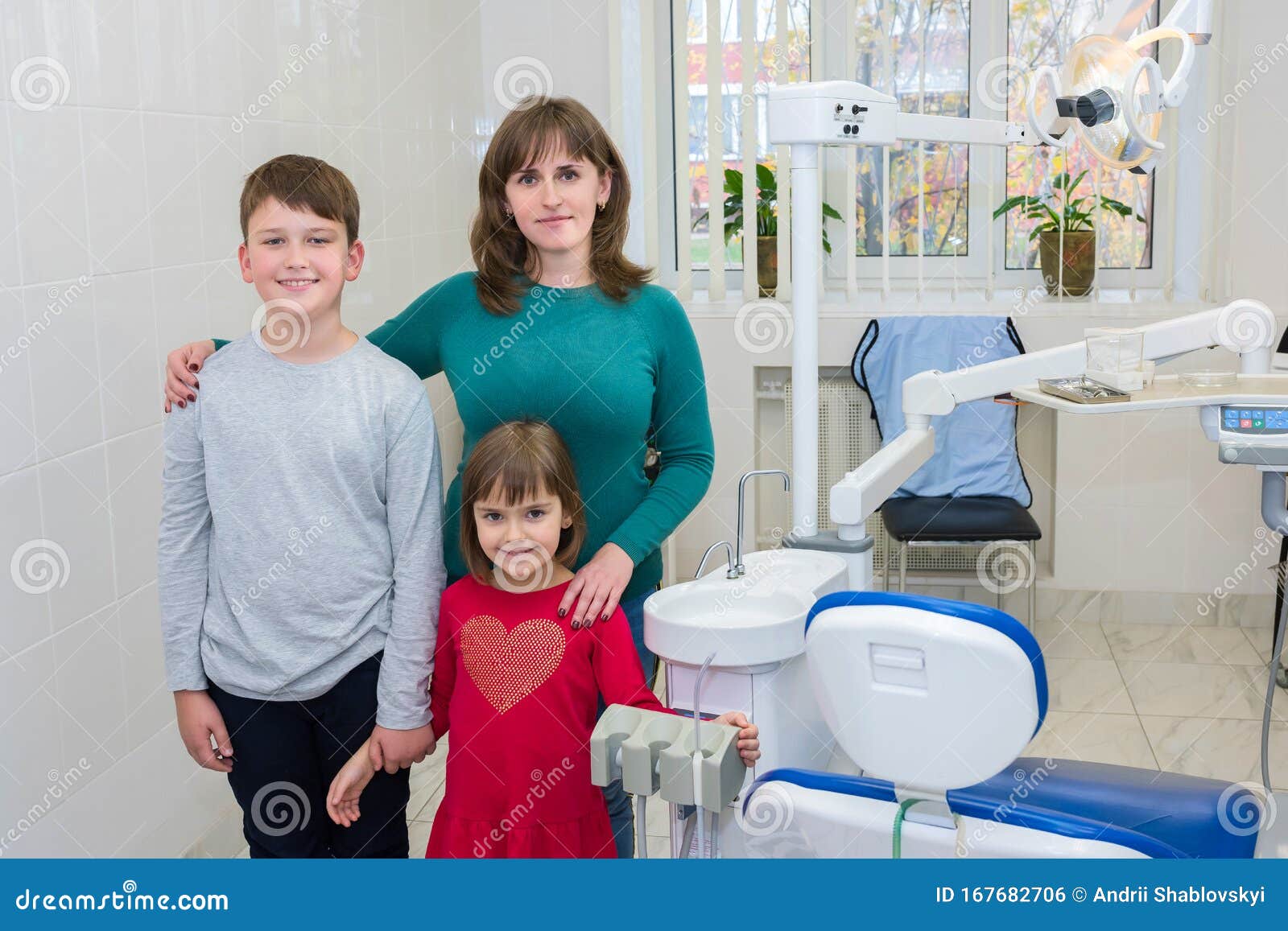 a happy family in a dentistÃ¢â¬â¢s office. medicine, dentistry and health care